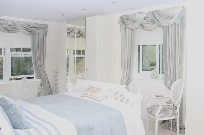 Swags and tails in a white bedroom by Heather Horrocks Leigh