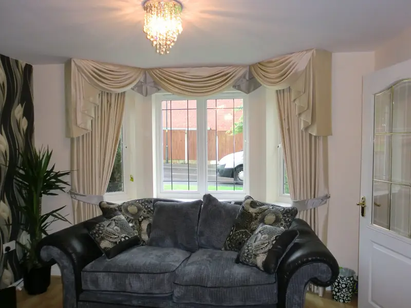 Cream swags and curtains in a bay window by Heather Horrocks Leigh